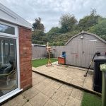 Back garden with shed and conservatory view.