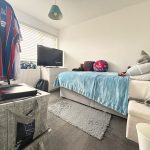 Bedroom with football decor and television.