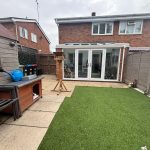 Suburban garden with artificial grass and patio furniture.