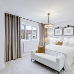 Modern white bedroom with stylish decor and lighting.
