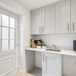 Modern utility room with sink and storage cabinets.