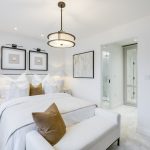 Modern white bedroom with elegant decor and ensuite.