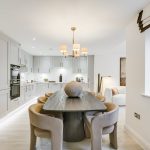Modern kitchen and dining area with wooden table.