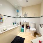 Modern bathroom with bathtub, shower, and toilet.