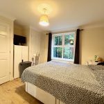 Cosy bedroom with double bed and large window.