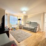 Cosy living room with sofa, toys, and TV.