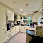 Modern kitchen with white cabinets and appliances.