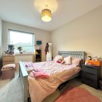 Cosy bedroom with double bed and soft lighting.