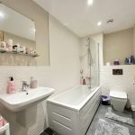 Modern bathroom with bathtub, sink, and toilet.