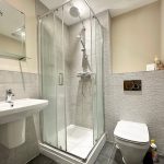 Modern bathroom with shower, sink, and toilet