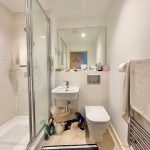 Modern bathroom with shower and sink.
