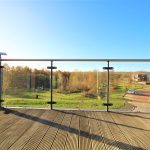 Scenic view from a modern balcony overlooking countryside.