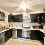 Modern kitchen with appliances and black cabinets.