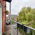 Balcony with panda statue and potted plants.