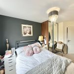 Cosy bedroom with modern decor and soft lighting.