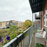 Balcony view with flowers and modern flats.