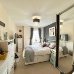 Cosy bedroom with mirror and decorative elements.