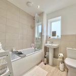 Modern bathroom with bath, shower, and toilet.