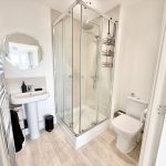 Modern bathroom with shower, sink, and toilet.