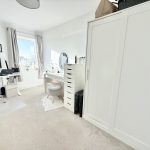 Modern home office with desk and wardrobe.