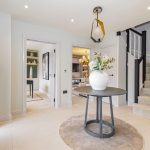 Modern hallway with round table and staircase.