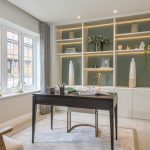 Modern home office with shelf and large window.