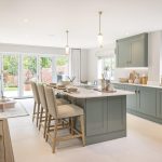 Modern kitchen with island and large windows.