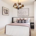 Modern bedroom with stylish decor and chandelier.
