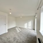 Empty room with carpet and large window.