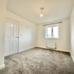 Empty room with grey carpet and white walls.