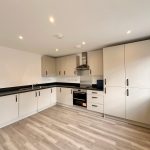 Modern kitchen interior with white cabinets and oven.