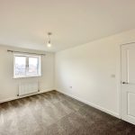 Empty room with window, carpet, and light fixture.