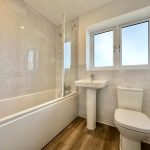 Modern bathroom with bathtub, sink, and toilet.