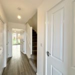 Modern hallway with stairs and outdoor view.
