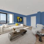 Modern blue living room with sofa and window view.