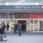 Milton Keynes Central train station entrance with passengers.