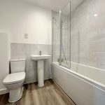Modern bathroom with bathtub, sink, and toilet.
