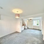 Bright living room with carpet and ceiling light.