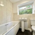 Modern bathroom with bathtub, sink, and toilet.