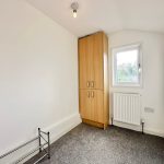 Small room with wardrobe, window, and radiator.