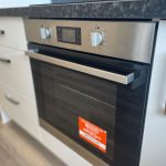 Modern built-in kitchen oven with digital display.