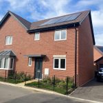 Modern brick house with solar panels and car.