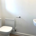 Minimalist white bathroom with toilet and sink.