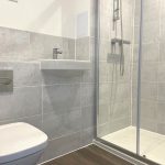 Modern bathroom with shower, sink, and toilet.