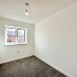 Empty room with grey carpet and window.