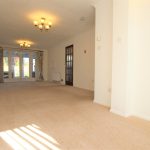 Spacious living room with chandeliers and garden view.