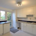 Bright kitchen with white cabinets and garden view
