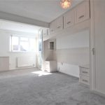 Spacious bedroom with fitted wardrobes and natural light.