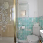 Bright bathroom with shower and turquoise tiles