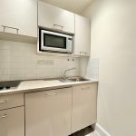 Modern small kitchen with microwave and sink.